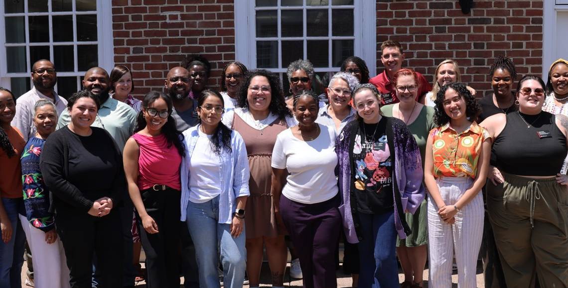 Photo of 18 staff members from cohort 1 standing together smiling