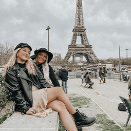 two students sit in front of the Eiffel Tower in Paris, France two students sit in front of the Eiffel Tower in Paris, France