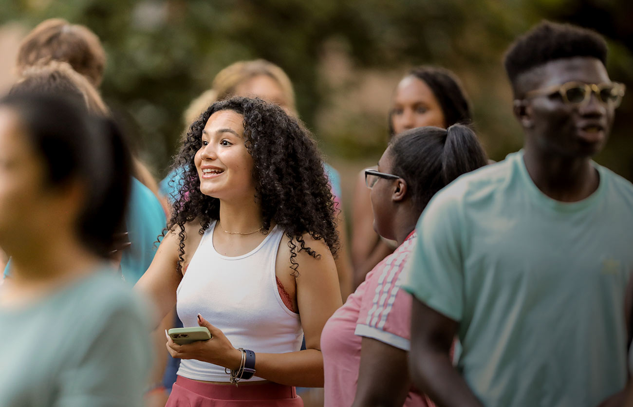 Students smiling and laughing walking on campus. 