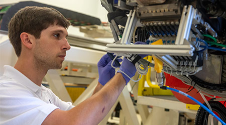 Graduate student working with a machine in the McNair Center.