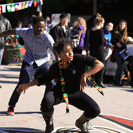 Two students dancing on green street during a Hip Hop Wednesday.
