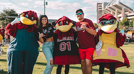 Students and their parents pose for a photo with Cocky and his parents at the Family Weekend Tailgate.