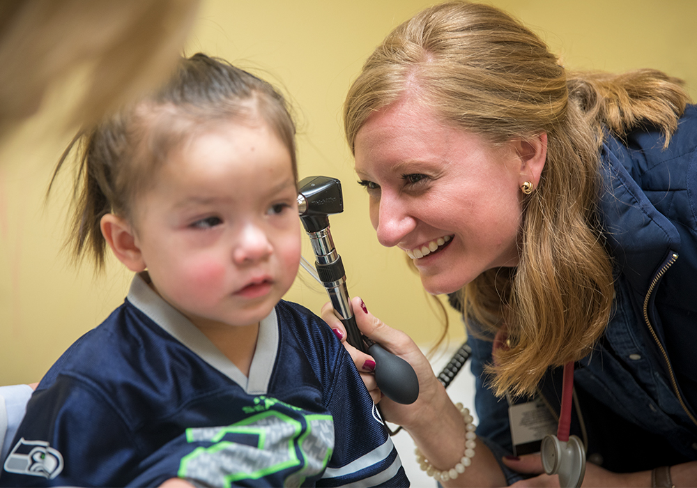 Doctor looking into a child's ear.