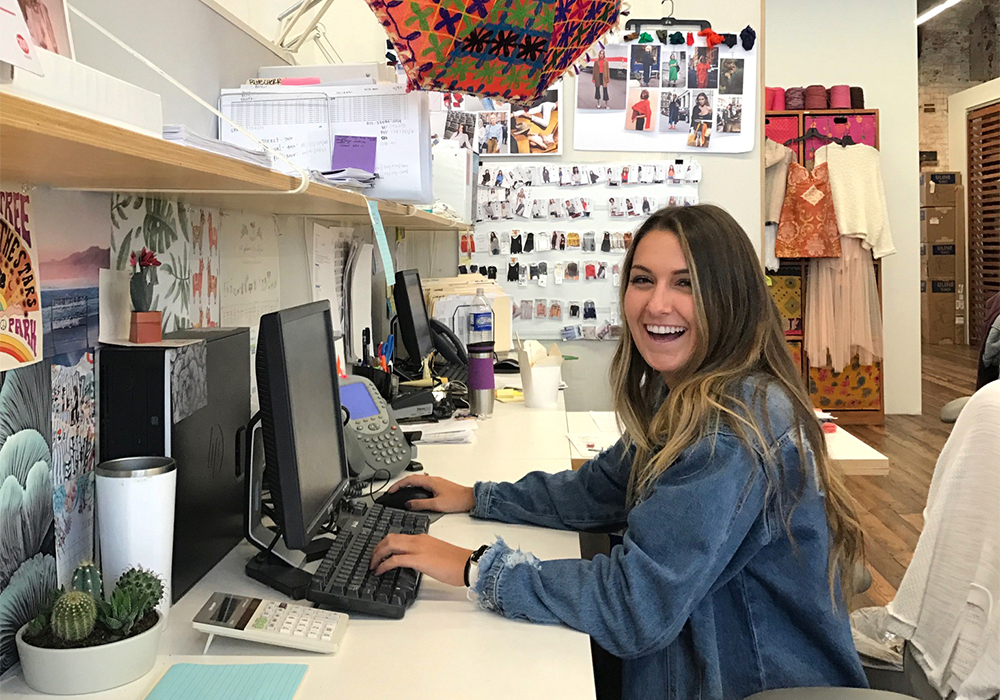 Students working at a computer at a fashion internship.