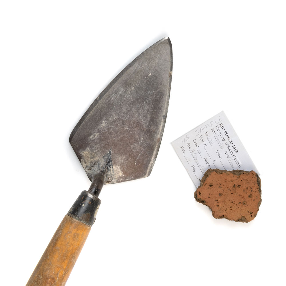 an archeology trowel and a rock