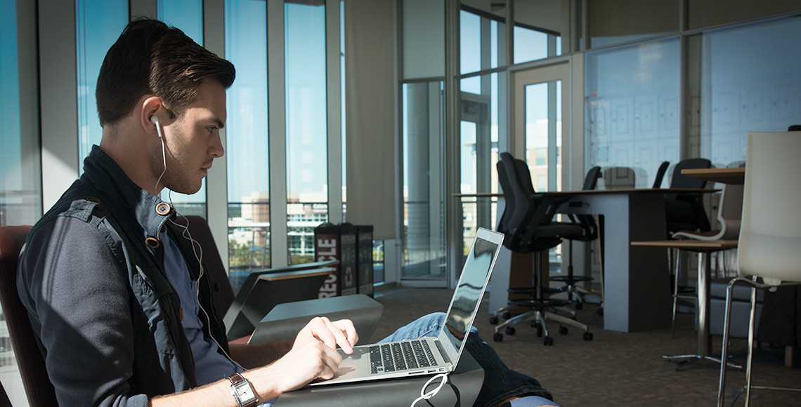 Male student using laptop