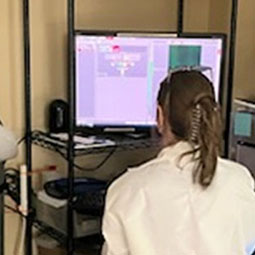 a woman working at a microscope