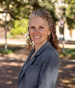 a woman outside in a gray suit