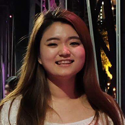 woman with long dark hair smiling outside