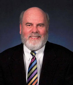 man with dark suit on smiling