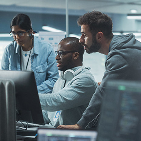 Three people looking at a computer screen