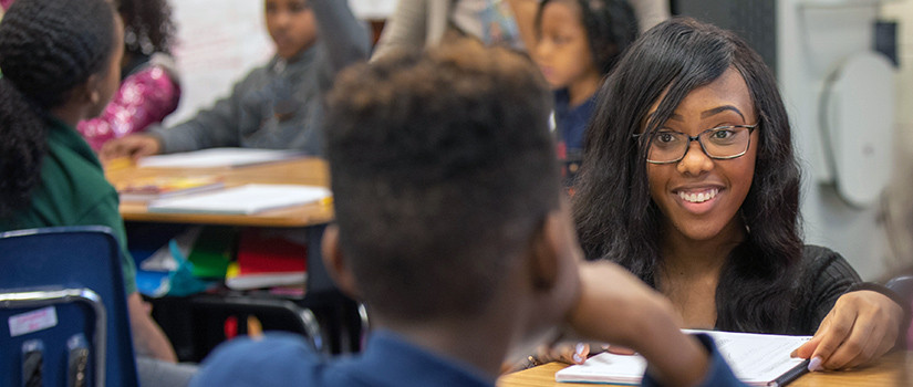 Elementary school teacher smiling at a student