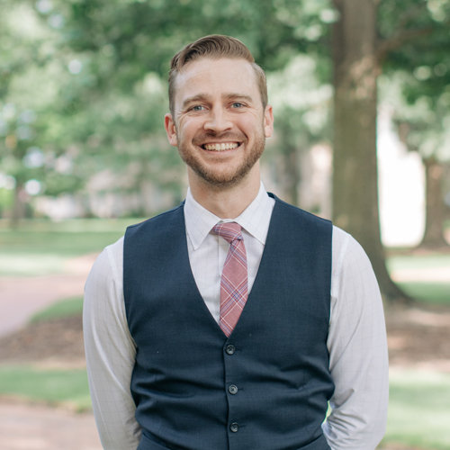 Headshot of young man smiling with light brown hair
