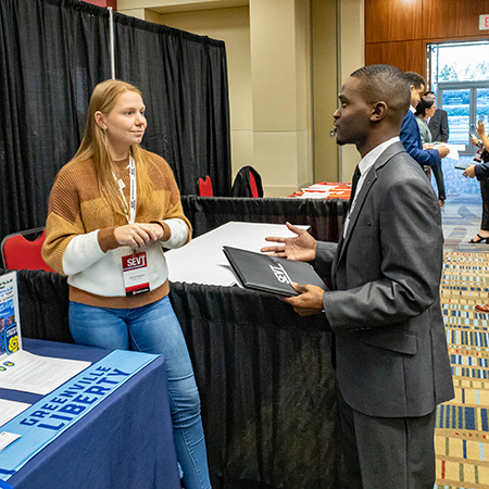 A recruiter speaks with a student at SEVT during a career fair. A recruiter speaks with a student at SEVT during a career fair.