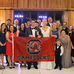 Lori Anna Varnadoe and Lee Davis Lori Anna Varnadoe and Lee Davis with their wedding party. The bride and groom hold a Gamecock banner.