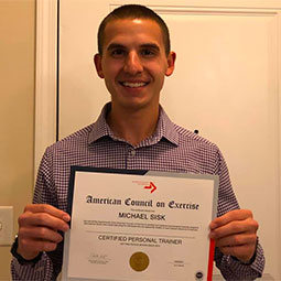 Michael Sisk Michael Sisk stands holding his accreditation certificate. Michael became an NCAA accredited personal trainer through the American Council on Exercise.