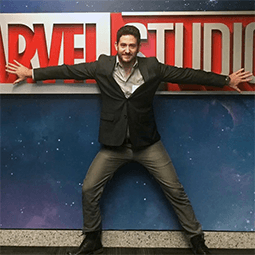 Brandon Davis Brandon Davis stands with arms spread across a Marvel Studios sign