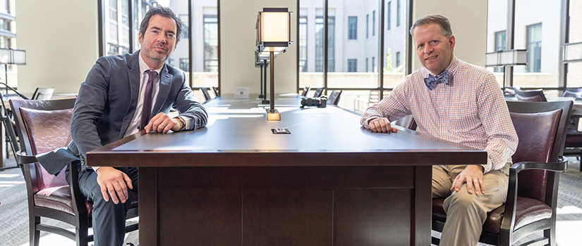 Ben Means and Joel Campbell sitting at table in law library reading room