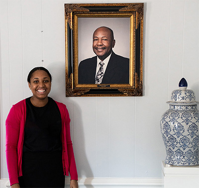 Woman standing next to portrait