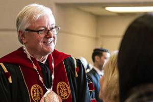 President Amiridis dressed in his regalia at the Presidential Investiture with the text Inside Carolina.