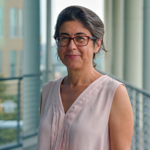 woman stands in front of a glass wall