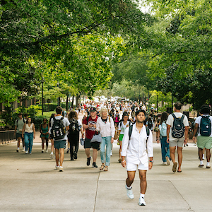 students walking across gray bridge on USC campus