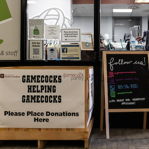 sign in front of shop that reads gamecocks helping gamecocks